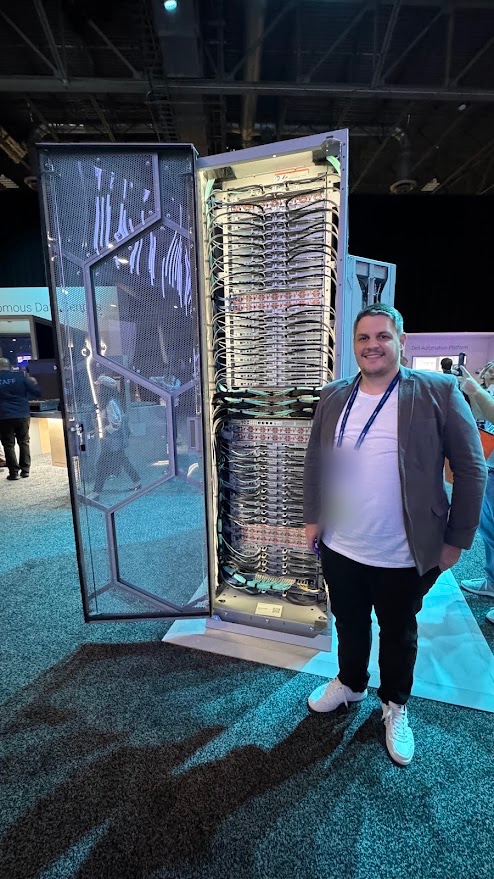Geraldo next to an open datacenter rack at a technology event